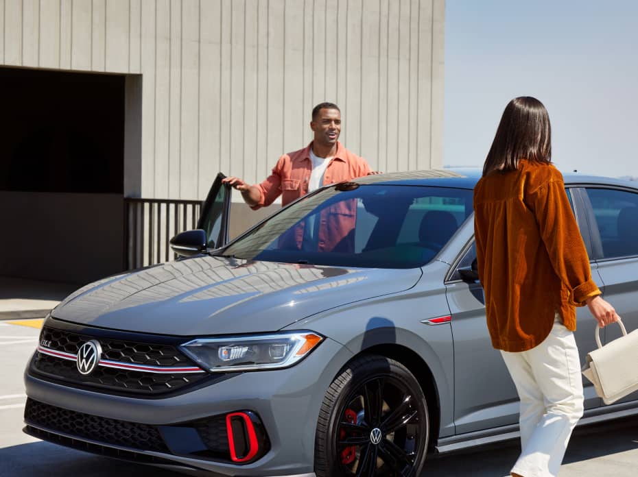 Two people getting into a VW car outside
