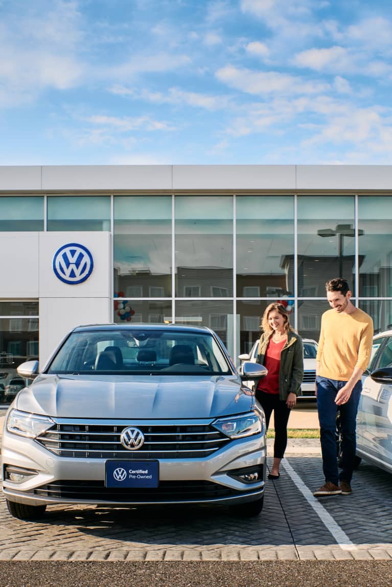 two people standing by a car